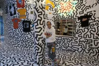 Keith Haring Stands in Front of his Art