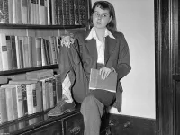 Carson McCullers Sitting in Front of Bookshelf