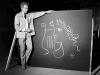 Jean Cocteau Stands Next to One of His Drawings