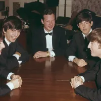 Brian Epstein With The Beatles in Tuxedos Sitting Around a Table