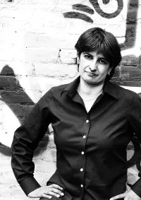 Urvashi Vaid in her Younger Years Standing in Front of a Brick Wall