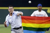 Billy Bean Throws Out Ceremonial First Pitch in 2016 With Pride Flag Held Up Behind Him